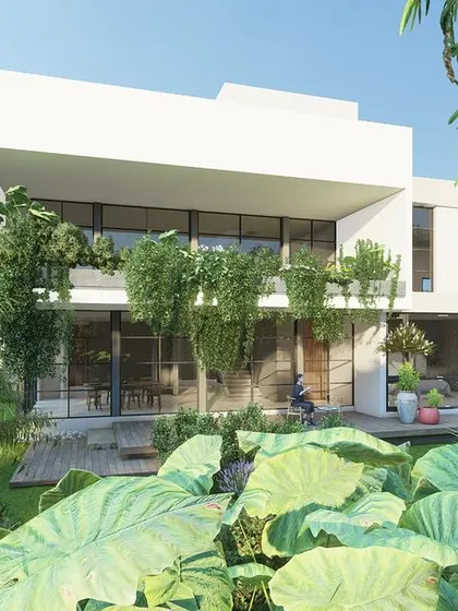 This view of the Hyderabad residence shows how the home is enveloped by greenery. The cantilevered upper floor creates a sheltered outdoor deck below.