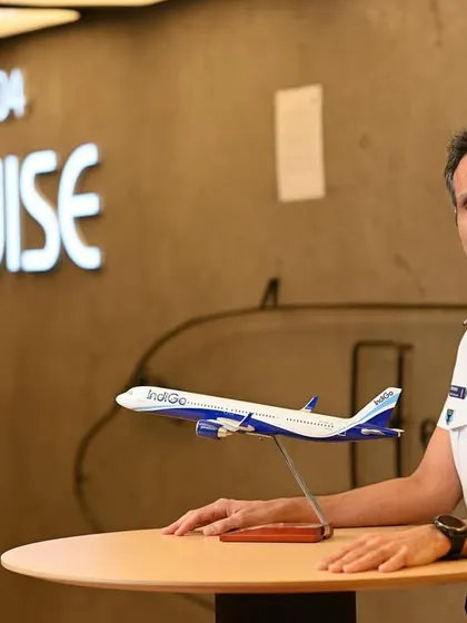 A portrait of an IndiGo pilot at the company's office. The setting and uniform work together to create a strong, on-brand image.