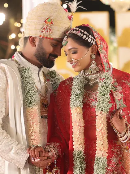 An intimate moment between the bride and groom, holding hands and sharing a quiet look. This candid shot captures the deep connection and emotion of the wedding ceremony.