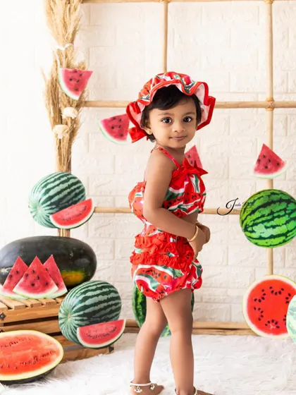 Dressed in a cute watermelon-print outfit with a matching hat, this little one is ready for her fruit-themed party. I provide themed costumes for many of my creative shoots.
