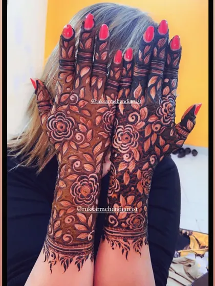 A client happily showing off her dark floral mehendi stain.