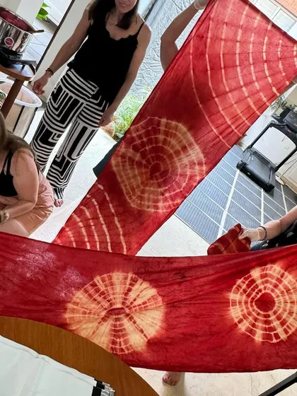 The stunning results of a tie-dye workshop. These long stoles, with their vibrant red and white patterns, show the beautiful effects that can be achieved with natural dyes.