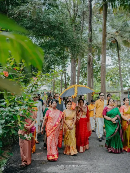The bride's procession, walking under an umbrella surrounded by family, a beautiful cultural tradition.