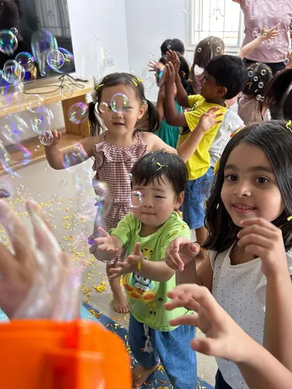 Pure joy! Children try to catch bubbles and flower petals during our Holi celebration.