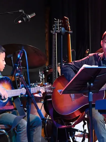 A close-up of our guitar duet, David and Samuel, concentrating on their piece. We encourage duo and small group performances to build musical communication skills.