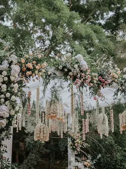 A close-up of the lush floral archway, featuring a mix of pastel roses and greenery, creating a romantic entrance.