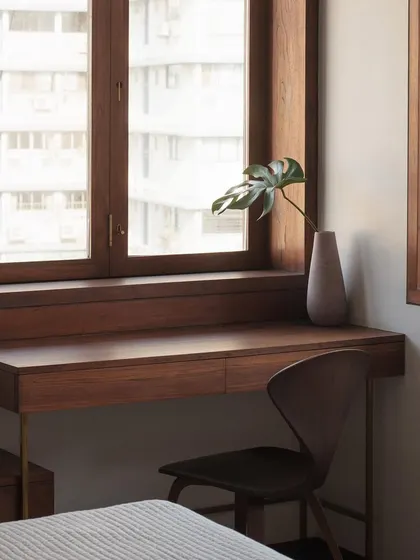 This custom desk and chair are perfectly fitted within the deep wooden window frame, creating a functional and serene workspace. The design demonstrates our approach to creating furniture that feels like a natural part of the architecture.