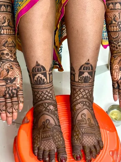 A creative pose showing the palms and feet together. This design features beautiful swan and peacock motifs, with coordinated architectural patterns on both hands and feet.