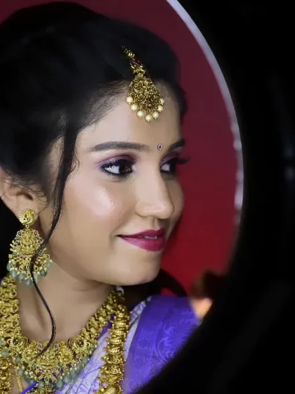 A profile shot of Sahana during her reception. The ring light captures the beautiful shimmer on her eyelids and the flawless finish of her makeup.