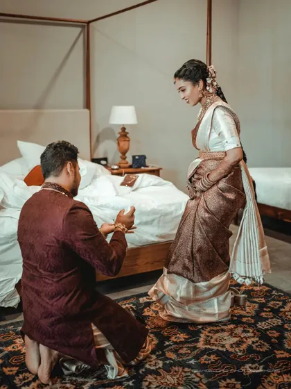 A private moment of proposal or gift exchange in their room. This intimate, candid shot tells a personal story away from the main festivities.