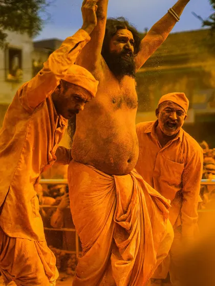 Action shots and crowd scenes from the turmeric festival, capturing the dynamic energy of the celebration. These images show devotees dancing, playing drums, and throwing clouds of yellow powder into the air.