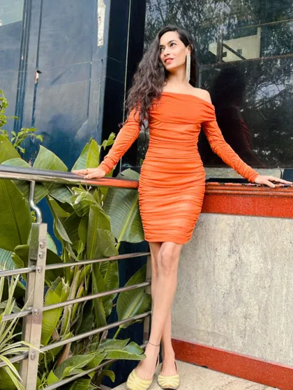 A pre-event moment in a vibrant orange dress. I always make sure my look is on point and ready for the stage.