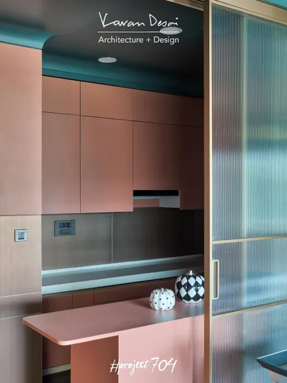 The kitchen in Project 704, finished in a warm pink with a fluted glass partition to separate it from the dining area. This allows for privacy while still letting light flow through the space.