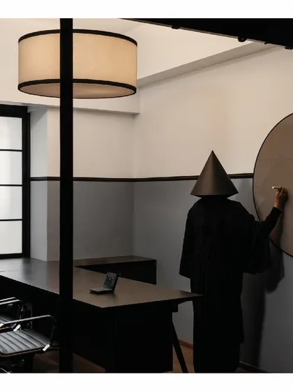 A large, round writing glass board was designed for this office cabin. It intersects with the wooden wall paneling, maintaining the clean, geometric forms that define the project's aesthetic.