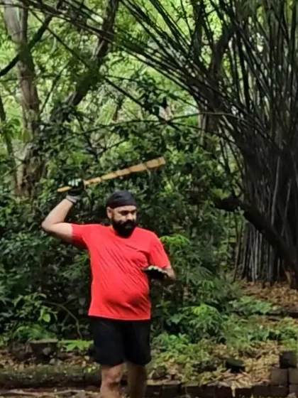 A student practices a striking motion with a stick. The focus and connection to nature during our outdoor sessions are a form of moving meditation.