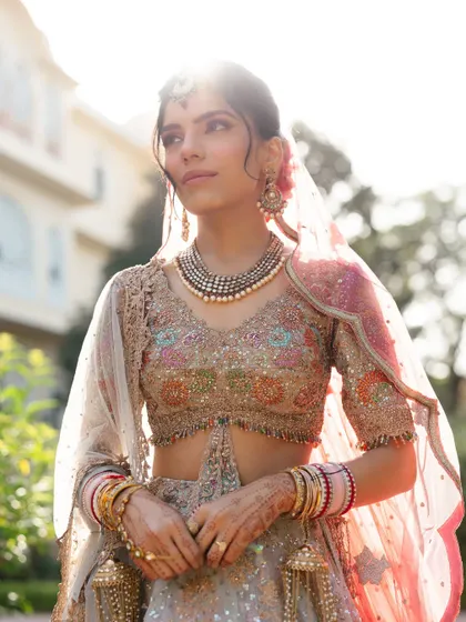 A beautiful bridal portrait with the sun creating a gentle flare behind her, highlighting her intricate jewelry and serene expression.