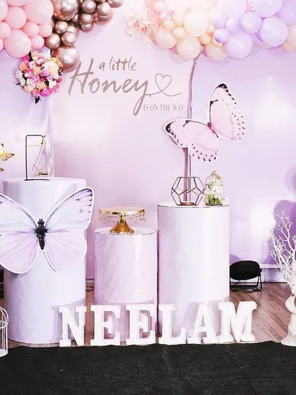 A full view of the butterfly-themed baby shower setup. The arrangement of pedestals, props, and balloons creates a beautiful and whimsical photo corner.