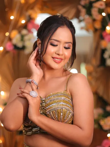 The complete look. This hairstyle perfectly complements the glamorous makeup and outfit, creating a cohesive and stunning appearance for any evening wedding event.