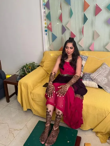 Another view of the bride with her complete hand and foot mehndi, looking radiant and happy.