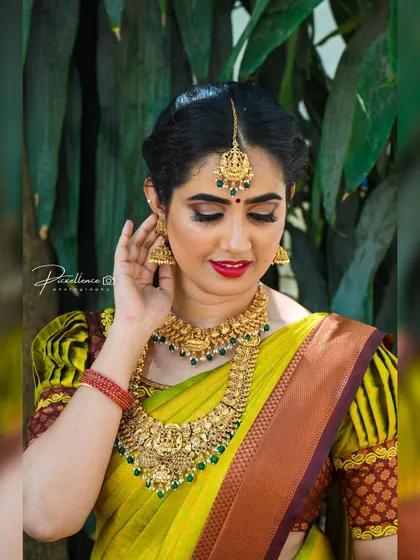 A closer look at the details. The eye makeup is soft yet defined, and the red lip adds a touch of classic glamour to her traditional South Indian bridal look.