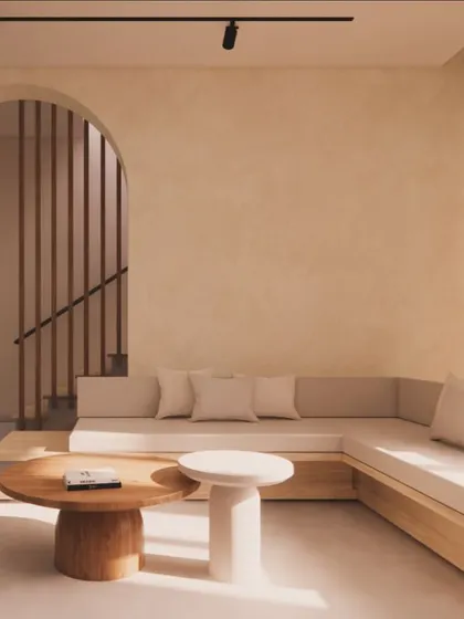 An example of my Japandi design style, this living area uses a neutral color palette, built-in low seating, and natural wood furniture. The arched entryway and lime-washed walls create a calm, minimalist, and tranquil atmosphere.