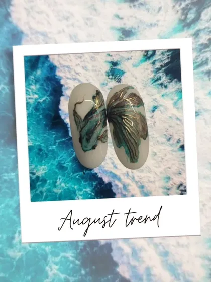 Announcing our August trend: this gorgeous, ethereal fish nail art. The design captures the graceful movement of a fish with delicate, flowing lines and a touch of gold.