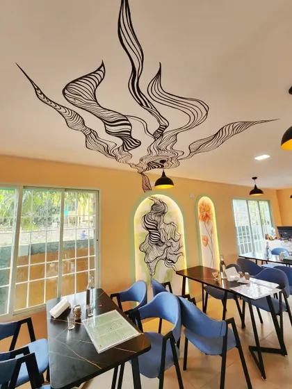 This shot highlights the artwork on the ceiling, creating a sense of movement and elegance above the dining tables.