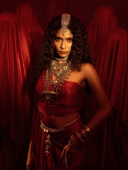 A powerful conceptual shot for a jewelry campaign. The use of red fabric and shrouded figures creates a dramatic and mysterious atmosphere.