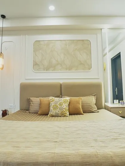 A front view of the bed, highlighting the elegant wall moulding and the warm, inviting color palette.