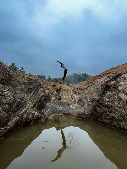 Stretching into Hasta Uttanasana, the raised arms pose, with my reflection in a natural pool of water. This pose is all about lifting and expanding your energy.
