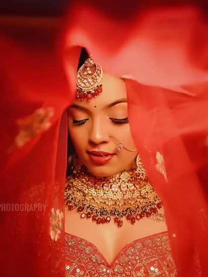 An artistic shot focusing on the bride's face through the movement of her veil, creating a soft and ethereal portrait.
