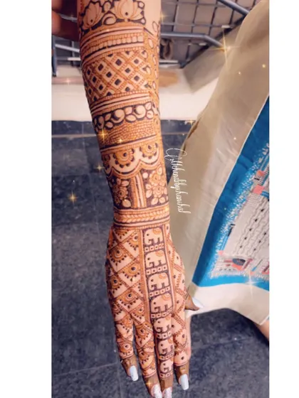 A side view of the engagement mehendi with elephant rows, showing the detail along the arm.