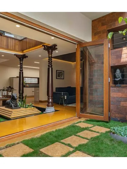 The indoor courtyard opens up completely to a private garden, merging the interior and exterior spaces into one cohesive, peaceful environment.