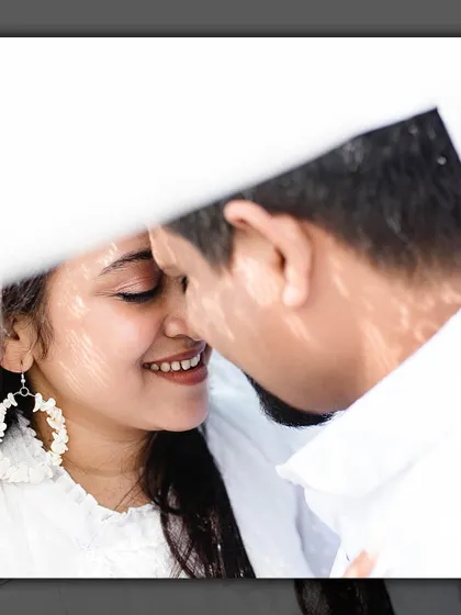 A creative close-up shot, using a white prop to frame the couple's faces for an intimate and artistic portrait.
