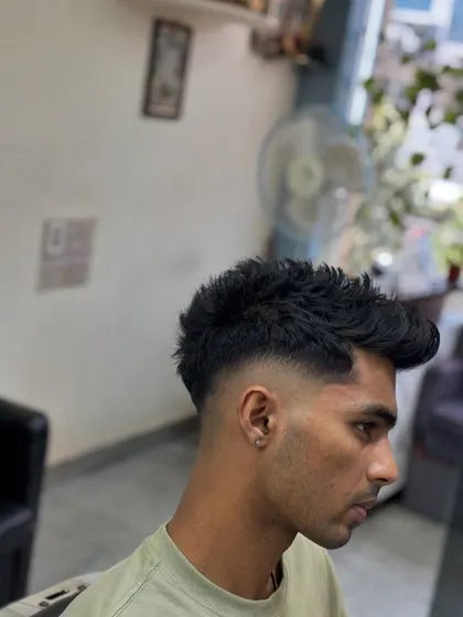 A close-up of the texture on top, styled to create volume and movement, contrasting with the sharp fade.