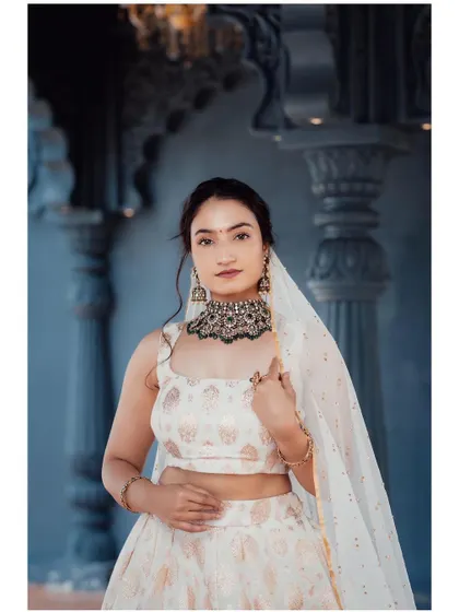 An identical portrait, providing a clear view of the blouse and jewelry.