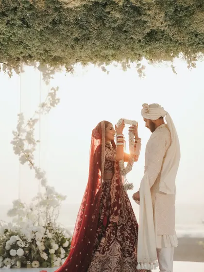 The varmala exchange against the setting sun. We timed the ceremony perfectly to capture this golden hour magic.