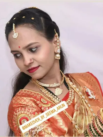 This reception look features a beautiful red Kanchipuram saree. The makeup is kept classic with a bold red lip and defined eyes, paired with traditional jewellery for a timeless and elegant appearance.
