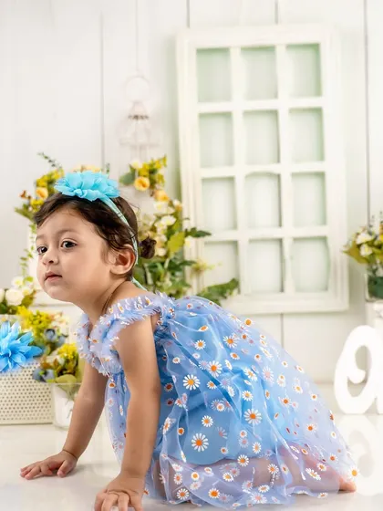 On the move. This crawling shot shows off the beautiful details of her dress and the whimsical floral studio setup for her first birthday.