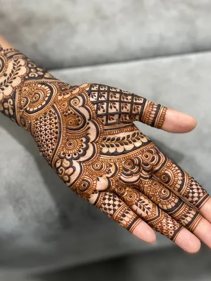 I really like the balance in this design, with its mix of delicate swirls, checkerboard patterns, and bold leaf motifs. It’s a wonderful example of a detailed back-hand mehendi.
