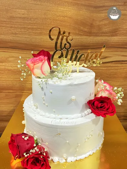 I believe every love story deserves a beautiful cake. This is a two-kilogram, two-tier Dutch Truffle engagement cake, decorated with fresh roses and baby's breath to mark the couple's special "It's Official!" moment.