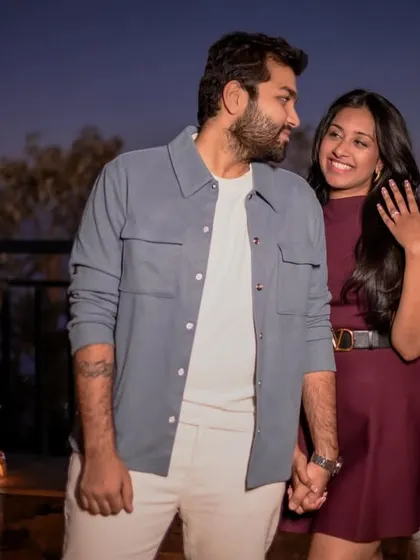 She proudly shows off her new engagement ring, holding his hand. A beautiful shot capturing the joy and excitement right after the proposal.