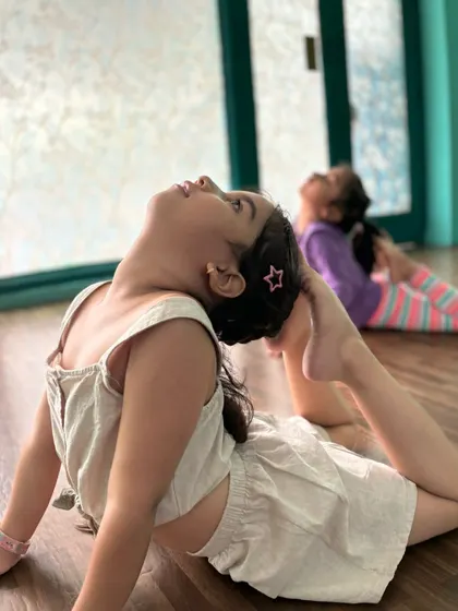 A young dancer practicing her cobra pose, which helps improve back flexibility and strength.