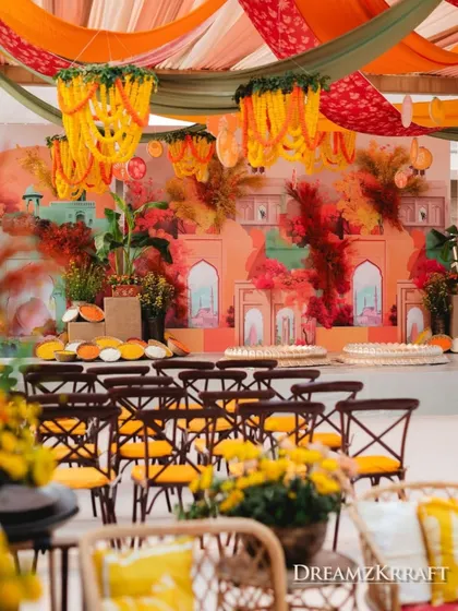 The 'Turmeric & Zataar' Haldi theme brought together Indian and Lebanese cultures. The backdrop is a custom mural depicting a fusion of palatial architecture, set against a riot of warm, spicy colors.
