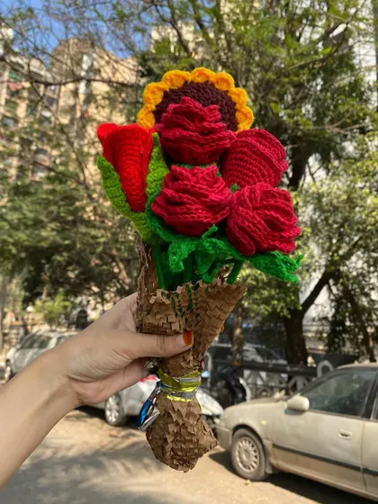A mix of classic red roses and a single sunflower, creating a bold and beautiful arrangement. A perfect handmade gift for any occasion.