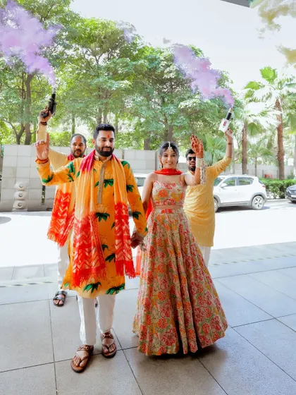 The couple's grand entrance to their Haldi ceremony with friends and colorful smoke bombs.