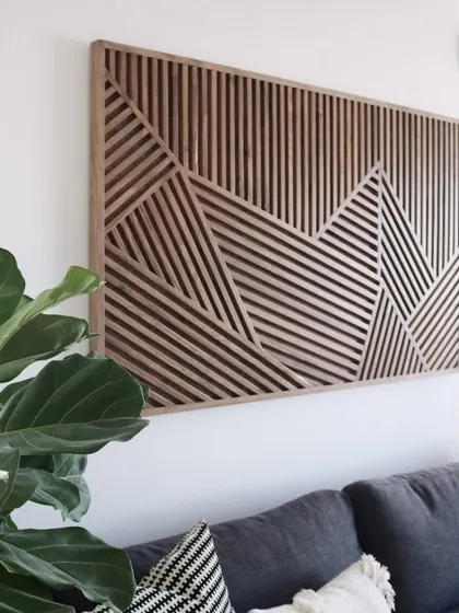 An angled view of the geometric stick art, highlighting the texture and depth created by the precisely placed wooden slats.