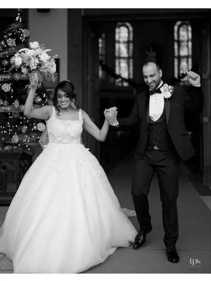 The joyful exit from the church, captured in a classic black and white photograph. The couple's happiness is palpable as they begin their new life together.