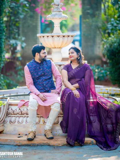 A candid and serene moment as a couple sits together by a fountain.