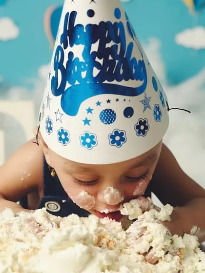 Diving right in. This photo captures the peak moment of a cake smash, showing the pure, uninhibited joy of the celebration.